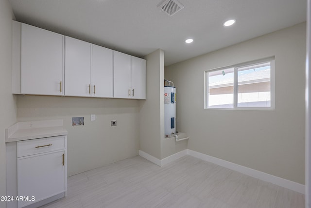 clothes washing area with cabinets, water heater, washer hookup, and electric dryer hookup