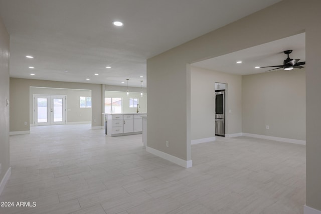 empty room featuring french doors, ceiling fan, and sink