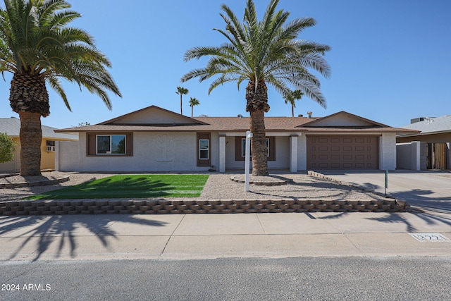 single story home with a front yard and a garage