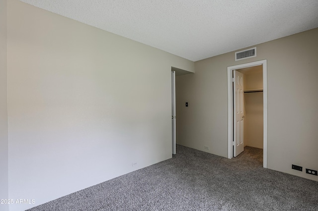 10410 N Cave Creek Rd Unit 2220, Phoenix, AZ 85020 - unfurnished bedroom with carpet, a walk in closet, a closet, and a textured ceiling