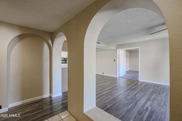 10410 N Cave Creek Rd Unit 2220, Phoenix, AZ 85020 - hall with dark wood finished floors, arched walkways, baseboards, and a textured ceiling