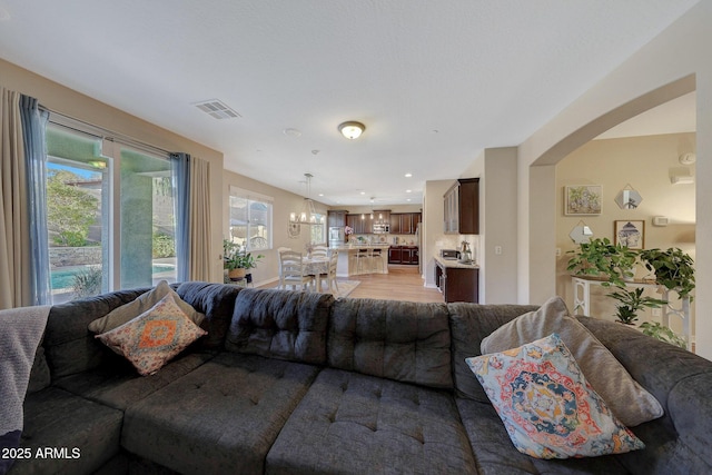 living room featuring light hardwood / wood-style flooring and a notable chandelier