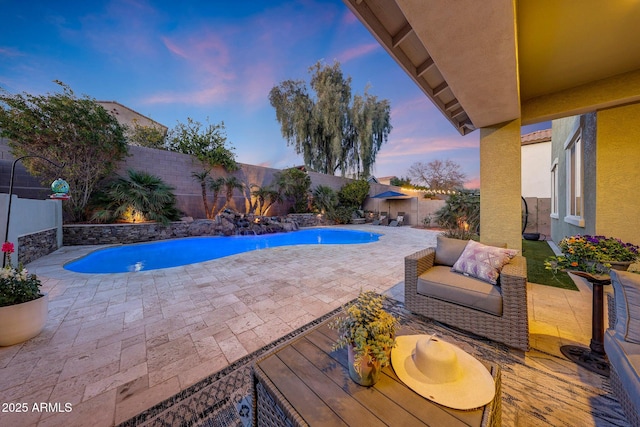 pool at dusk featuring a patio area