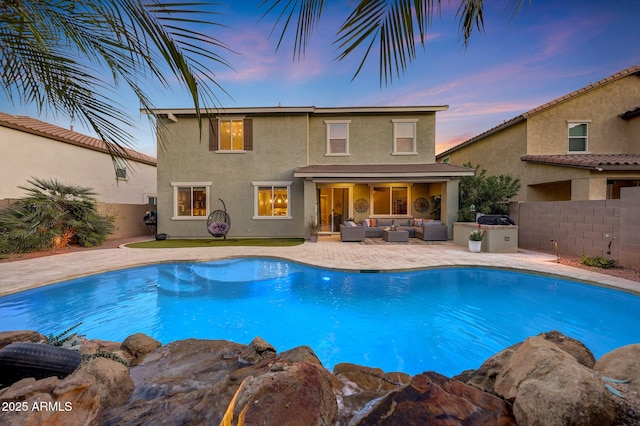 pool at dusk featuring outdoor lounge area