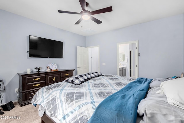 carpeted bedroom featuring ceiling fan and ensuite bath