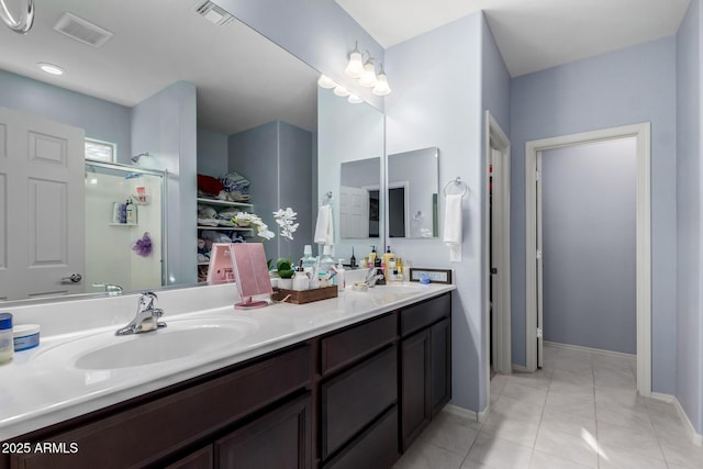 bathroom featuring a shower with door, tile patterned floors, and vanity