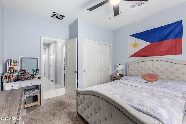 bedroom with a closet, light tile patterned floors, and ceiling fan