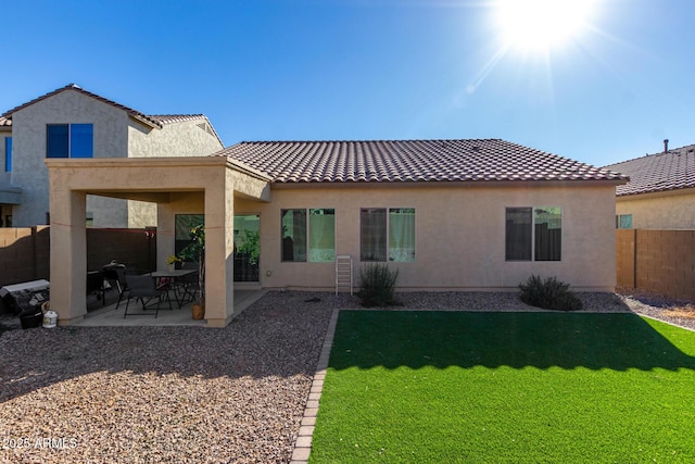 back of property featuring a patio area and a lawn