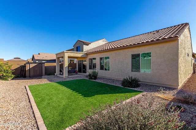 back of property featuring a patio area and a yard