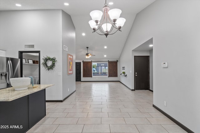 kitchen with high vaulted ceiling, stainless steel fridge with ice dispenser, hanging light fixtures, light tile patterned floors, and ceiling fan with notable chandelier