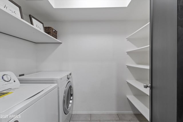 clothes washing area with light tile patterned floors and washer and dryer