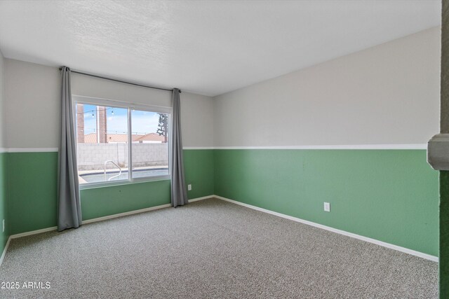 spare room with carpet and a textured ceiling