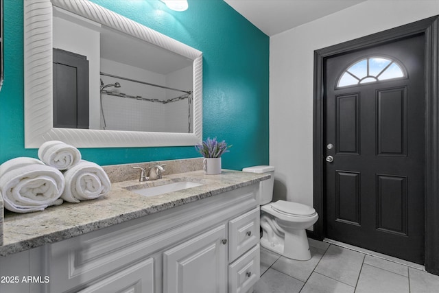 bathroom featuring vanity, toilet, tile patterned flooring, and a shower