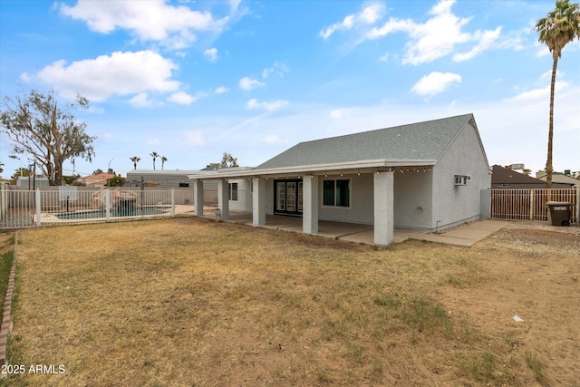 rear view of property featuring a patio, a swimming pool, and a lawn