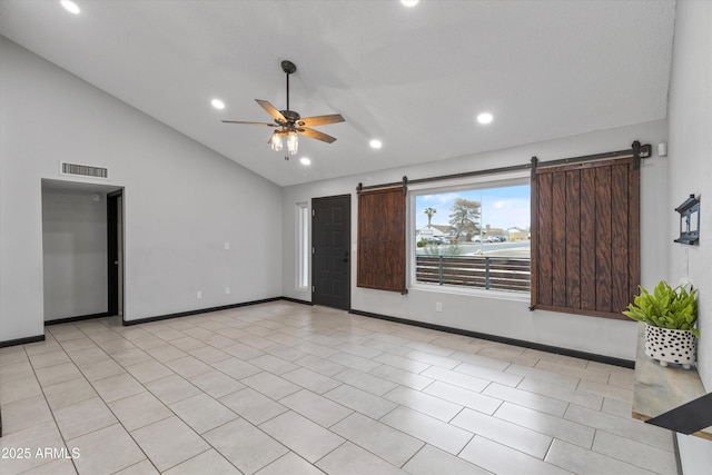 tiled spare room featuring a barn door, high vaulted ceiling, and ceiling fan