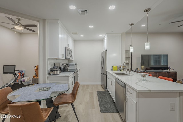 2038 E River Rd Unit 101, Tucson, AZ 85718 - kitchen with appliances with stainless steel finishes, a sink, ceiling fan, light wood-style flooring, and white cabinets