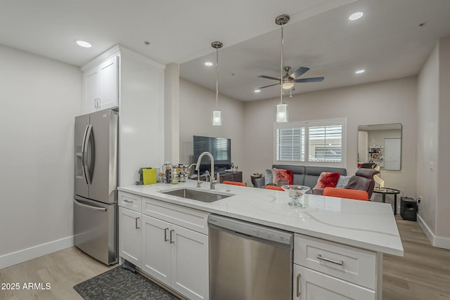 2038 E River Rd Unit 101, Tucson, AZ 85718 - kitchen featuring appliances with stainless steel finishes, a sink, open floor plan, light wood-type flooring, and recessed lighting