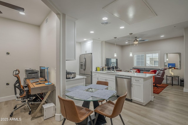 2038 E River Rd Unit 101, Tucson, AZ 85718 - kitchen with appliances with stainless steel finishes, a ceiling fan, a sink, light wood-type flooring, and a peninsula