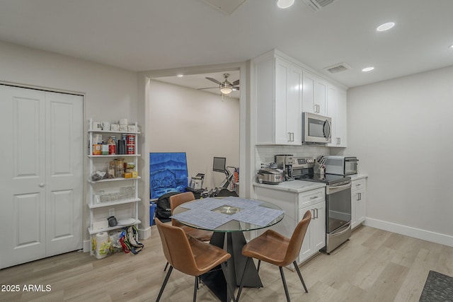 2038 E River Rd Unit 101, Tucson, AZ 85718 - kitchen with stainless steel appliances, light wood-style flooring, a ceiling fan, white cabinetry, and backsplash