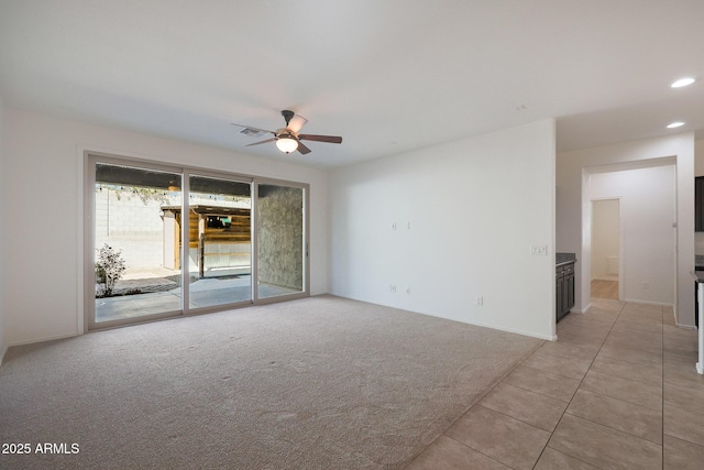 carpeted spare room with ceiling fan