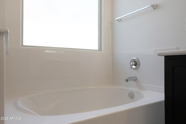 bathroom featuring a bathing tub, vanity, and plenty of natural light