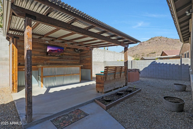 view of patio / terrace featuring a hot tub and a mountain view