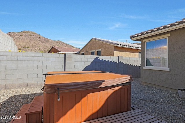 view of yard with a hot tub and a mountain view