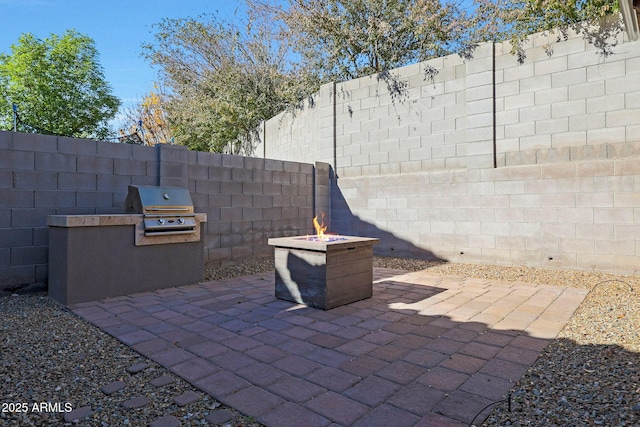 view of patio with exterior kitchen, grilling area, and a fire pit