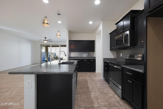 kitchen with decorative light fixtures, a kitchen island with sink, appliances with stainless steel finishes, ceiling fan, and sink