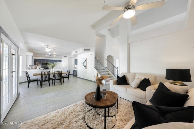 living room featuring visible vents, stairway, a ceiling fan, and light wood-style flooring