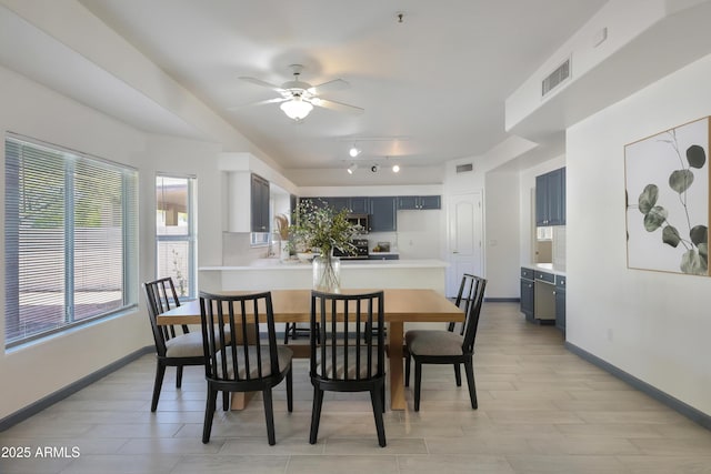 dining room featuring baseboards, visible vents, ceiling fan, and rail lighting
