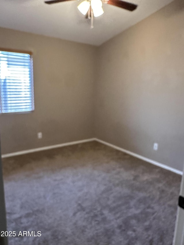 empty room with dark carpet and ceiling fan