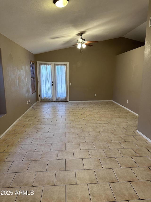 tiled spare room with ceiling fan and vaulted ceiling