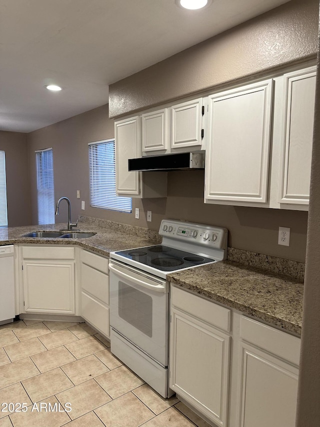 kitchen with white appliances, light tile patterned floors, sink, and white cabinets