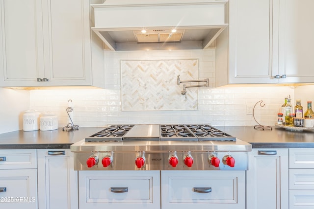 kitchen featuring stainless steel gas stovetop, custom range hood, and white cabinets