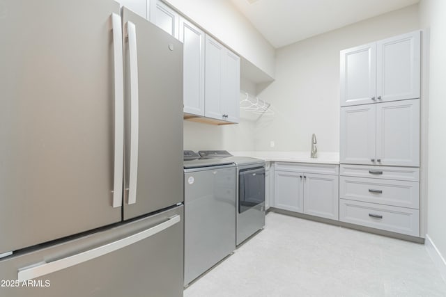 washroom featuring sink, washer and clothes dryer, and cabinets