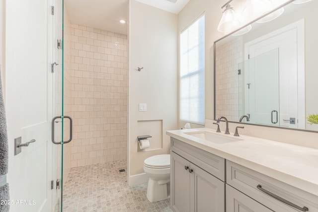 bathroom with vanity, a shower with shower door, and toilet