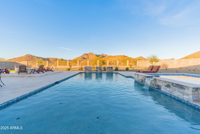 view of pool with a patio, a mountain view, a jacuzzi, and pool water feature