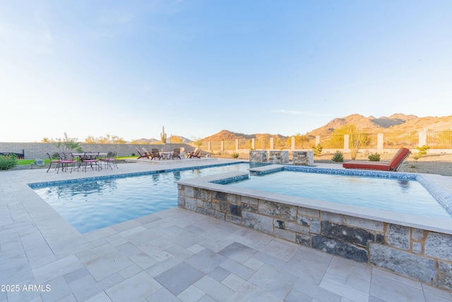 view of pool with a jacuzzi, a mountain view, and a patio