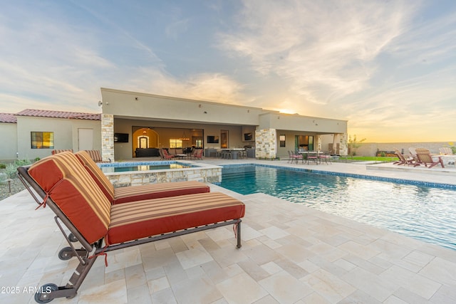 pool at dusk with a patio area