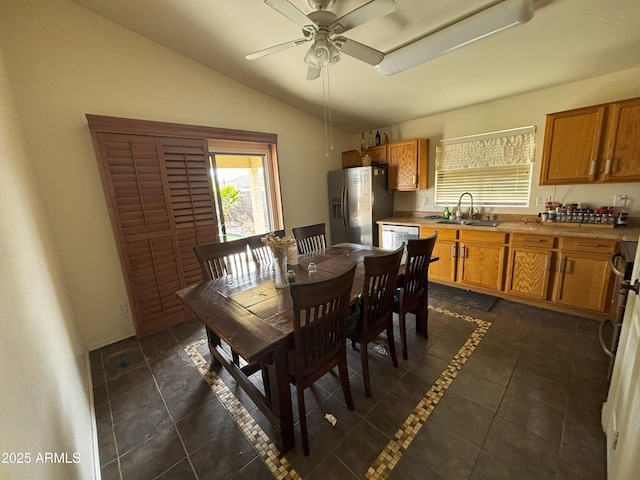 dining area featuring vaulted ceiling, ceiling fan, dark tile patterned flooring, and sink