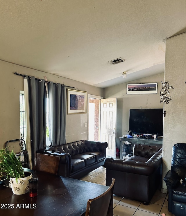 tiled living room featuring lofted ceiling and a textured ceiling