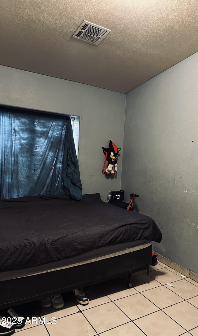 tiled bedroom with a textured ceiling