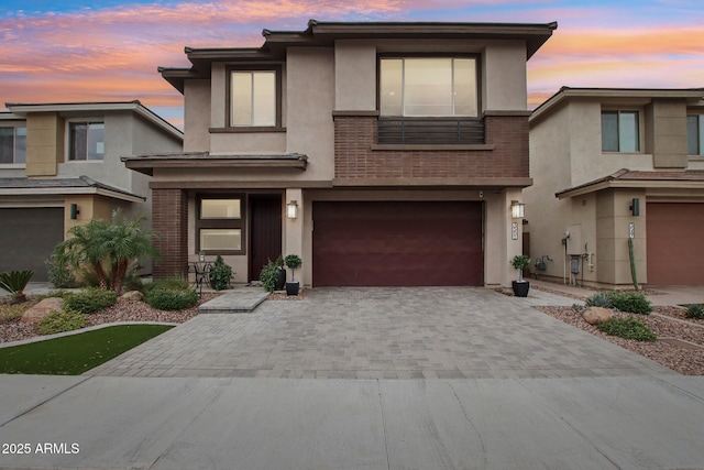 view of front of house with driveway, a garage, and stucco siding