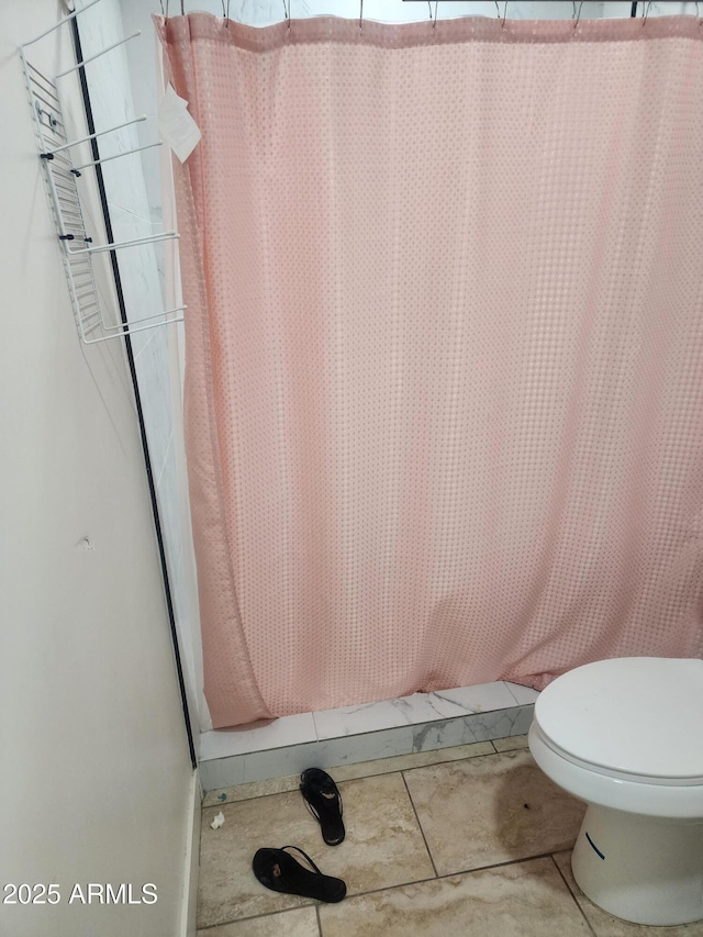 bathroom with toilet and a shower with curtain