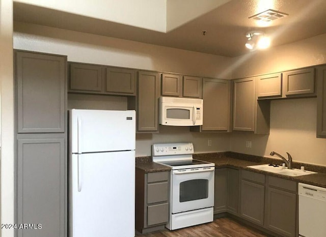 kitchen featuring dark hardwood / wood-style flooring, white appliances, and sink