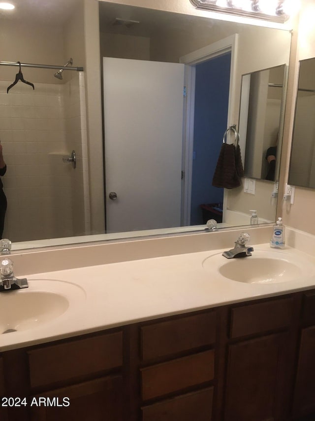 bathroom featuring a shower and vanity