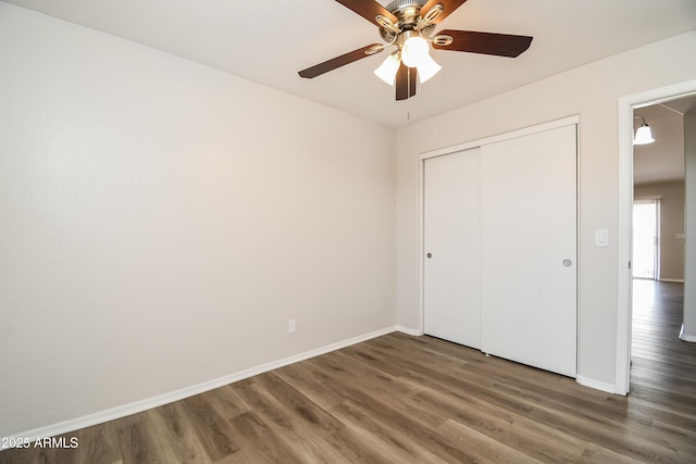 unfurnished bedroom with a ceiling fan, a closet, baseboards, and wood finished floors