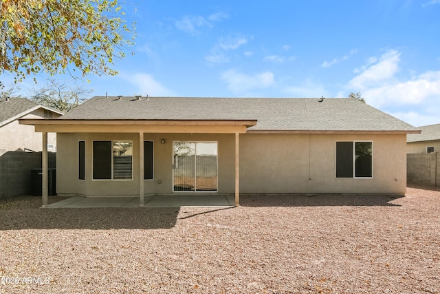 back of property with a patio, roof with shingles, a fenced backyard, and stucco siding