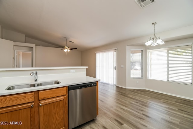 kitchen featuring visible vents, dishwasher, lofted ceiling, brown cabinets, and a sink